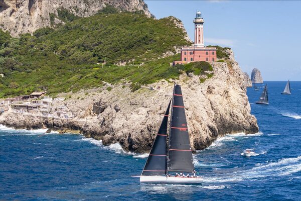 Guido Paolo Gamucci's canting keel Mylius 60 Cippa Lippa X passes Capri's imposing lighthouse at Punta Carena. Photo: IMA / Studio Borlenghi